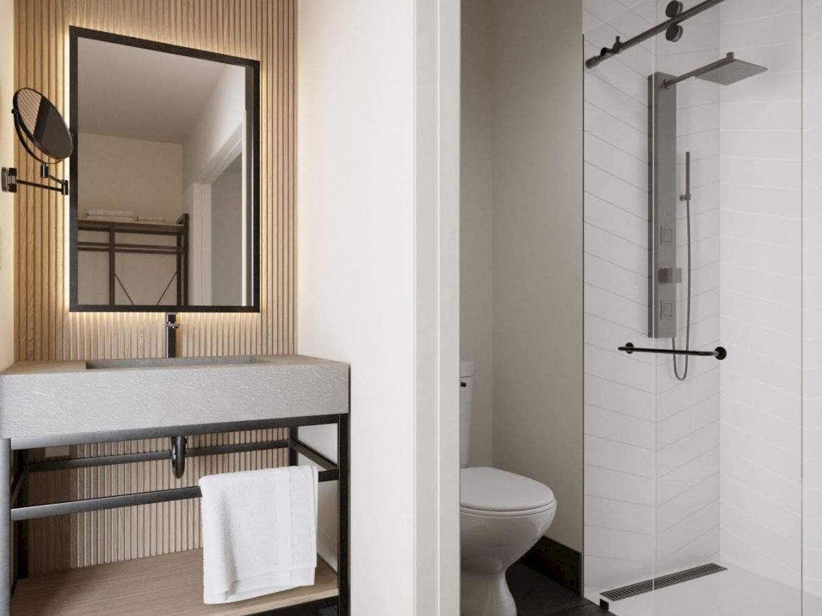 A modern bathroom with a vanity, mirror, towel, toilet, and glass-enclosed shower on dark tiled flooring.